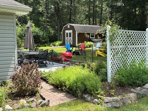 A backyard with a barbecue grill, outdoor furniture, and a wooden shed. - Catskills Getaway: 3BR Retreat w/ Media Room, Near Casino, Bethel Woods & More! (Glen Wild)
