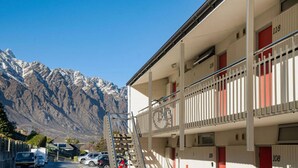 A multi-story hotel with balconies and a mountain view. - Couples Retreat - Million Dollar Wakatipu Views! (Queenstown)
