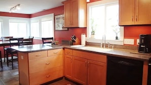 A kitchen with wooden cabinets, a dishwasher, and a coffee maker.