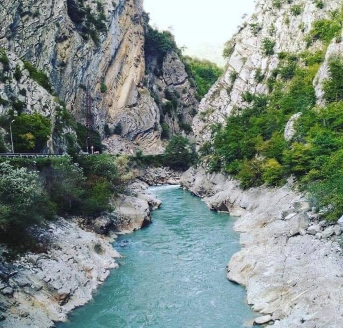 A river flowing through a rocky gorge with steep cliffs on either side.