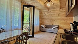 A wooden cabin interior with a dining area, sofa, and kitchen. -  chalet in amazing village Tsesi with big history and beautiful view (Tsesi)