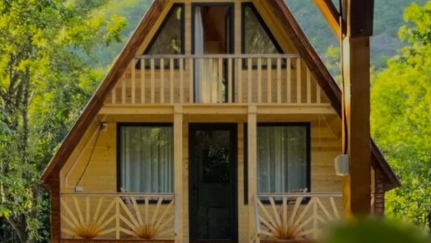 A wooden cabin with a balcony, a front door, and a small porch. -  chalet in amazing village Tsesi with big history and beautiful view (Tsesi)