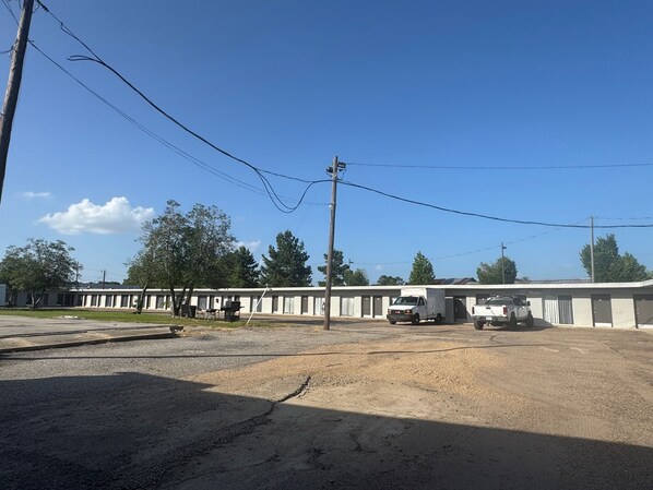 A motel with a row of rooms, a parking area, and a truck parked in front.