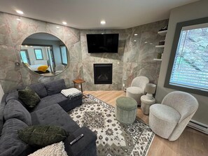Smart TV, chimenea, libros y monitor de computadora