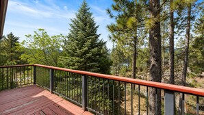 A wooden deck with a metal railing overlooking a forested area. - Silver Rays (Big Bear Lake)