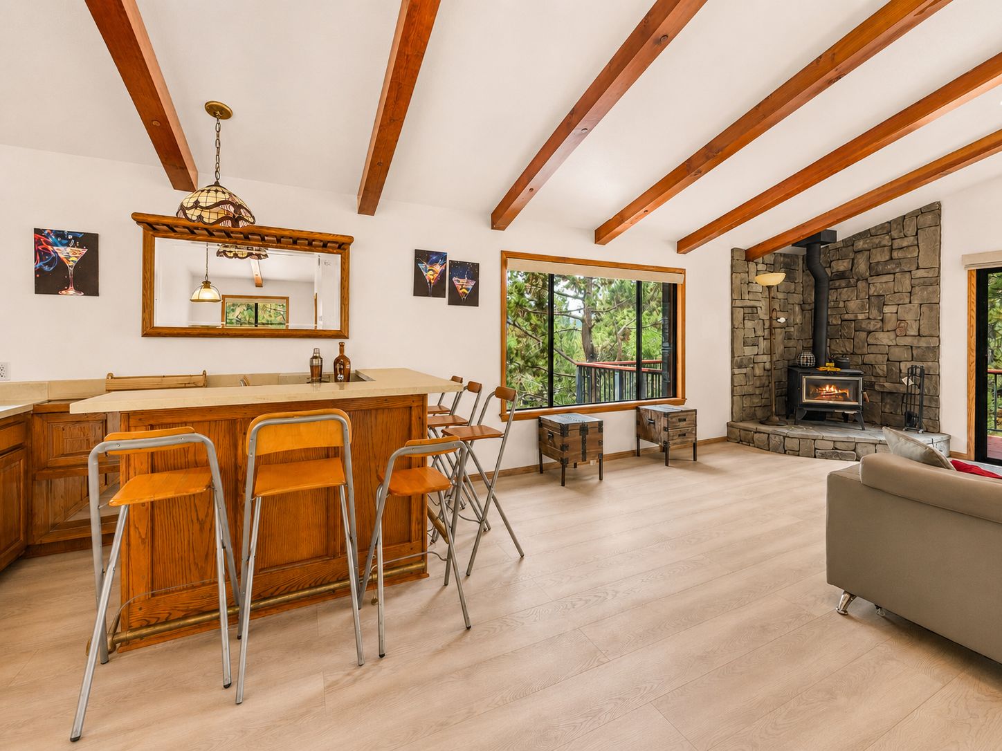 Une cuisine spacieuse avec un îlot central, des chaises en bois, une table à manger et une cheminée en pierre.