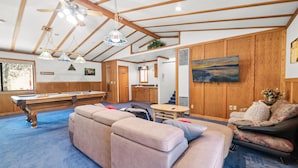 A spacious living room with a pool table, a sofa, and a dining area. - Silver Rays (Big Bear Lake)