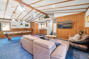 A spacious living room with a pool table, a sofa, and a dining area. - Silver Rays (Big Bear Lake)