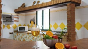 A kitchen with a tiled backsplash, a microwave, and a wooden shelf above the stove. - El Molinillo de Jimera Jimera de Libar by Ruralidays (Málaga)