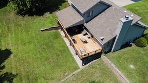 Vista aérea de una casa de dos pisos con un balcón, un porche cubierto y un garaje.
