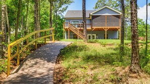 Ein Haus mit einer Holzterrasse und einer Treppe, die zu einem zweiten Stock führt.