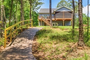A house with a wooden deck and a staircase leading to a second floor. - Lake Hartwell Family Getaway w/ Dock & Water Views (Lavonia)