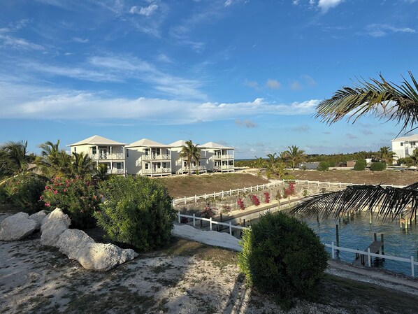 A beachfront property with multiple white buildings, a sandy beach, and a pool area. - Panoramic views of the Pool, the Atlantic Ocean and the vibrant marina (Great Guana Cay)