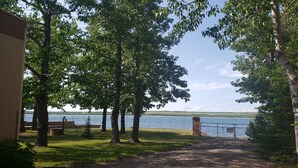 Ein Kiesweg führt zu einem See, der von Bäumen gesäumt ist.