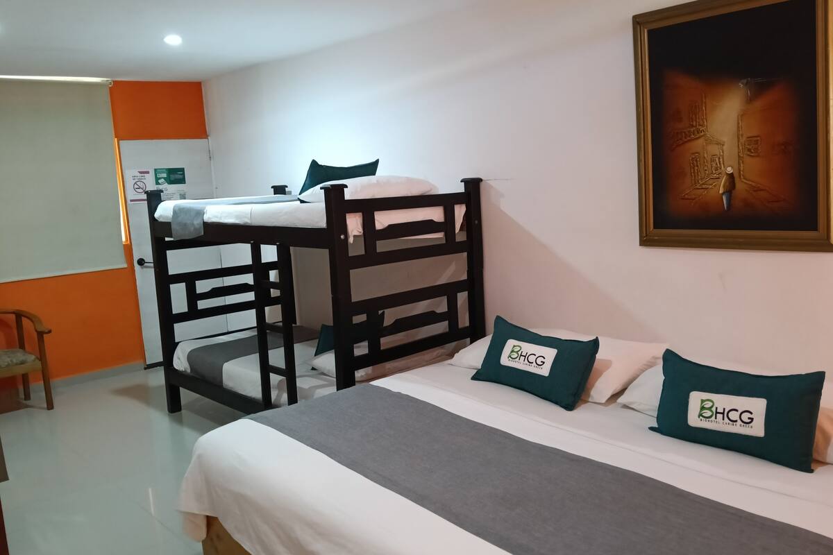 Habitación con literas, una silla y un cuadro en la pared.