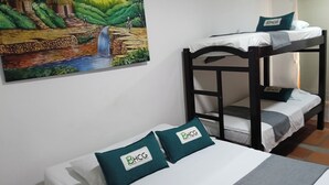 Habitación con literas y un cuadro de un paisaje tropical en la pared.