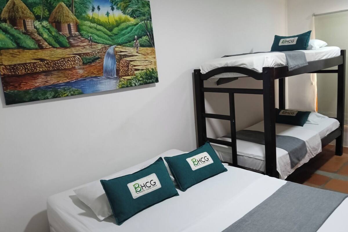 Habitación con literas y un cuadro de un paisaje tropical en la pared.
