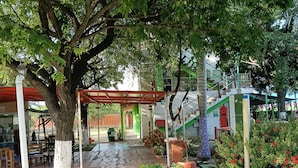 Un espacio al aire libre techado con una pérgola, asientos y plantas en macetas.