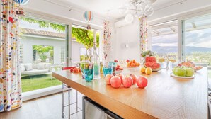 A modern kitchen with a wooden countertop, large windows, and a view of a green garden. - The Secret Escape Villa: Contemporary Luxury in Lucca (Lucca)