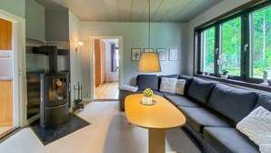 Uma sala de estar moderna com sofá, mesa de centro e área de jantar.