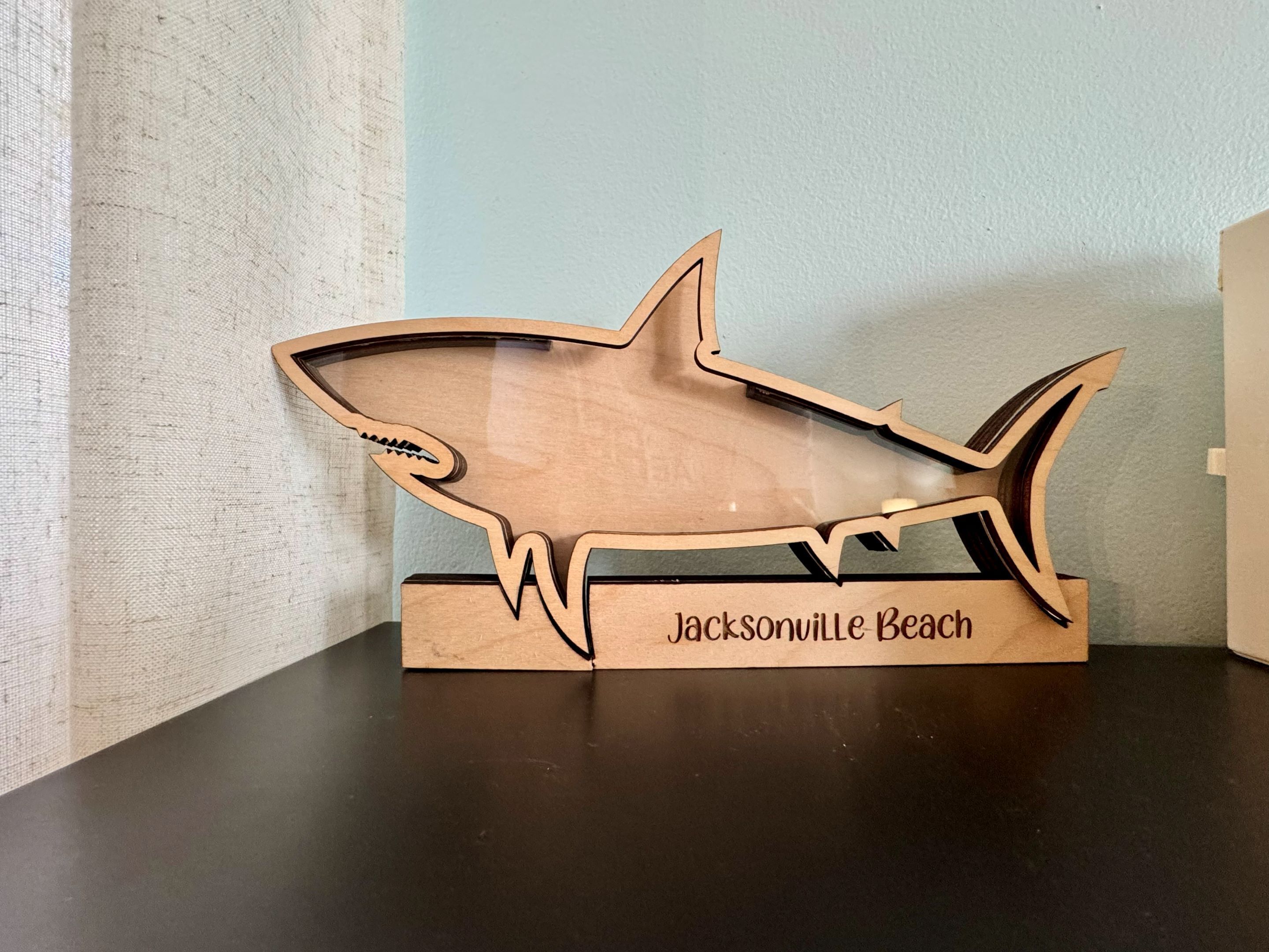 Ein Schlüsselanhänger in Form eines Holz-Hais mit dem Schriftzug "Jacksonville Beach".
