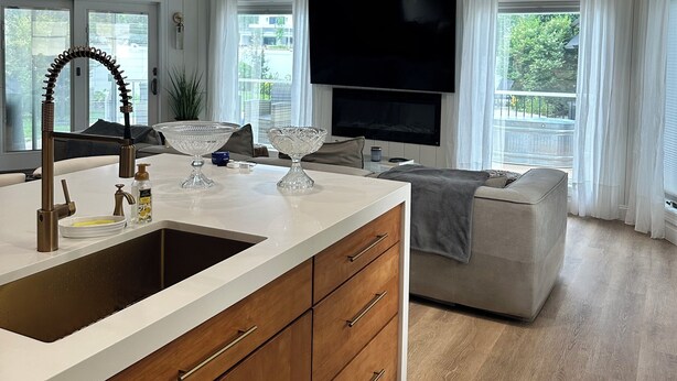 A modern kitchen with a central island, wooden cabinets, and a built-in oven.
