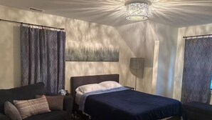 Un dormitorio moderno con cama, sofá y una lámpara de pie.