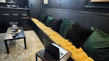 A modern living room with a sofa, a coffee table, and a laptop on a side table.