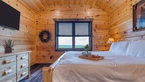 A wooden cabin room with a bed, dresser, window, and a wreath on the wall. - All Fun & Games by Avantstay Indoor Pool, Game Room, Theater, Mountain Views Near Pigeon Forge & Dollywood (Sevierville)