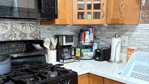 Una cocina moderna con estufa, microondas y cafetera.