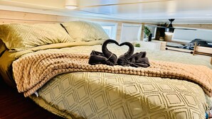 A bed with a geometric patterned duvet, a swan-shaped pillow, and a swan-shaped blanket. - Couple’s retreat in Tiny Home w soaking tub/beach at Upper Lake (Upper Lake)
