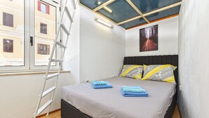 A bedroom with a bed, a ladder, a skylight, and a cityscape poster. - Apartment 2396/160471 (Istria - Pula), 110m from the beach (Pula)