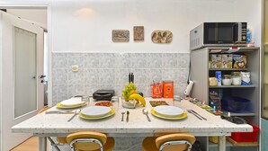 A kitchen with a dining table set for four, equipped with plates, cutlery, and glasses. There are various food items and condiments on the counter. - Apartment 2396/160471 (Istria - Pula), 110m from the beach (Pula)