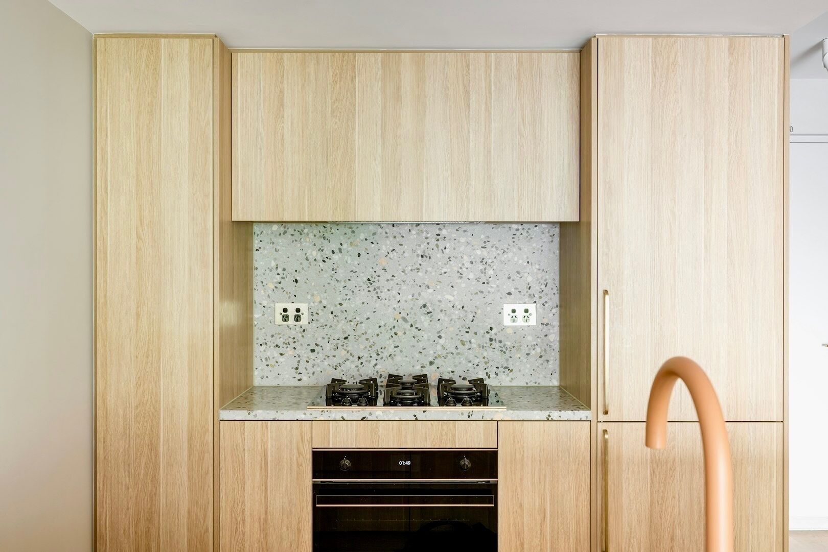 Cocina con gabinetes de madera, encimera de granito y lavavajillas.