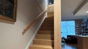 Un escalier en bois, doté d’une rampe, mène à l’étage supérieur.