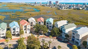 A residential area with houses, a road, and a body of water in the background.