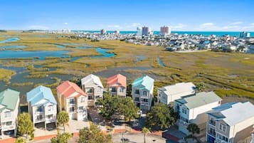 Un quartier résidentiel avec des maisons, une route et une étendue d’eau en arrière-plan.