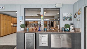 Una cocina con refrigerador empotrado, un lavamanos y una ventana.