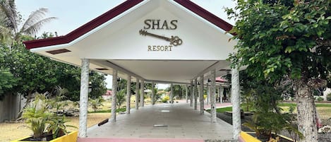 A covered entrance to Shas Resort with a tiled floor and a red roof.