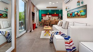 Una sala de estar moderna con un sofá, una mesa de centro y un comedor con una mesa y sillas.