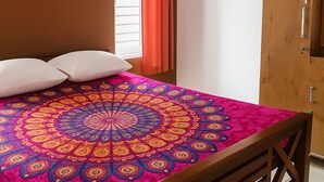 Un dormitorio con cama, armario y ventana con cortinas.