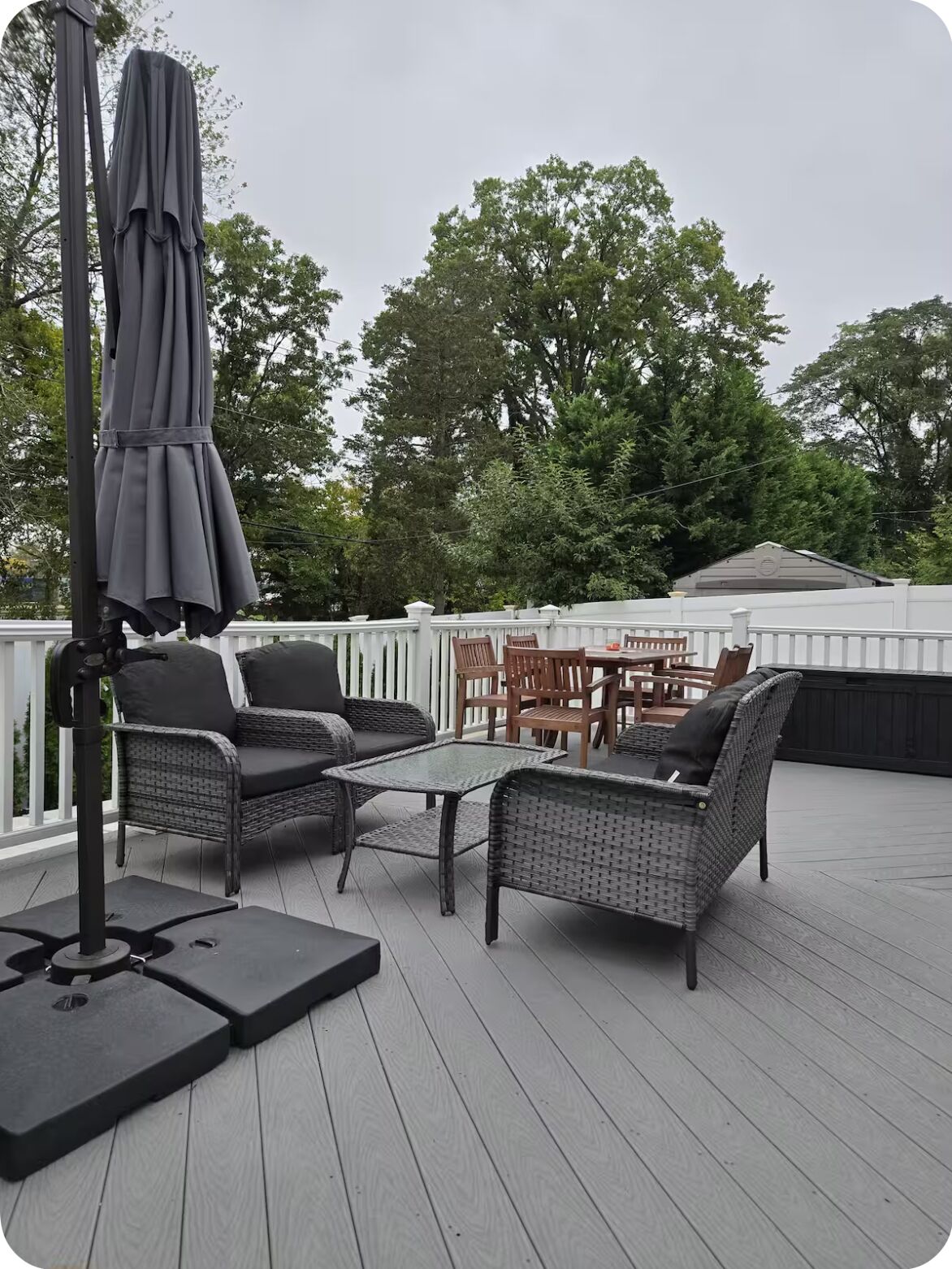A covered outdoor patio with wicker furniture, a table, and an umbrella.