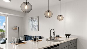 A modern kitchen with a white countertop, grey cabinets, and pendant lighting. - Luxury 2Bd Condo DT Minneapolis, Minutes From Convention Center & US Bank Arena (Minneapolis)
