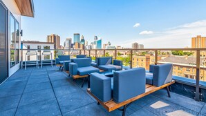 A rooftop terrace with modern seating and a city view. - Luxury 2Bd Condo DT Minneapolis, Minutes From Convention Center & US Bank Arena (Minneapolis)
