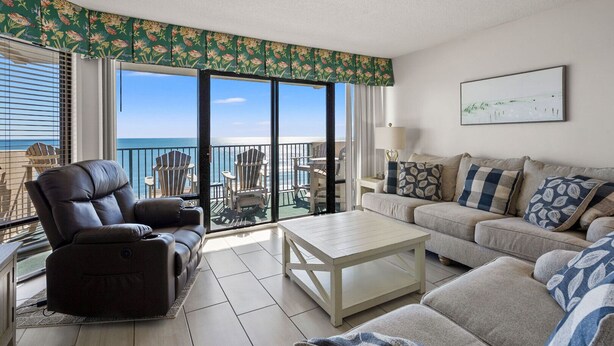 A living room with a view of the ocean, a leather recliner, a sofa, and a coffee table. - Oceanfront 4BR condo with stunning views, balcony, pool & beach access in North Myrtle Beach (North Myrtle Beach)