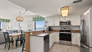 A modern kitchen with white cabinets, stainless steel appliances, and a granite countertop. - Oceanfront 4BR condo with stunning views, balcony, pool & beach access in North Myrtle Beach (North Myrtle Beach)
