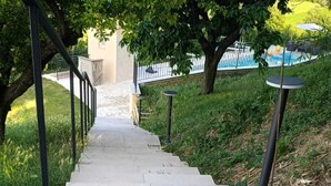 Una escalera de concreto que conduce a un edificio, con barandas metálicas a cada lado.