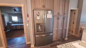 A kitchen with wooden cabinets, a stainless steel refrigerator, and a water dispenser. - 50 minute ride to the Little League fields (cammal)