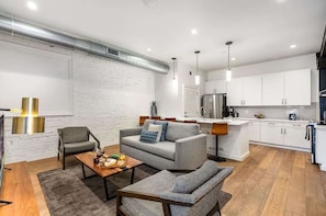 A modern kitchen with white cabinets, a stainless steel refrigerator, and a central island.