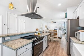 A modern kitchen with granite countertops, stainless steel appliances, and a central island.